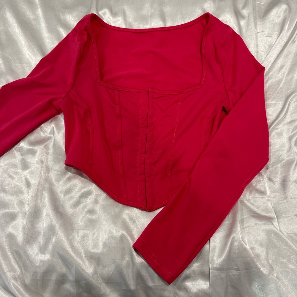 hot pink long sleeve crop top with corset details and a square neckline